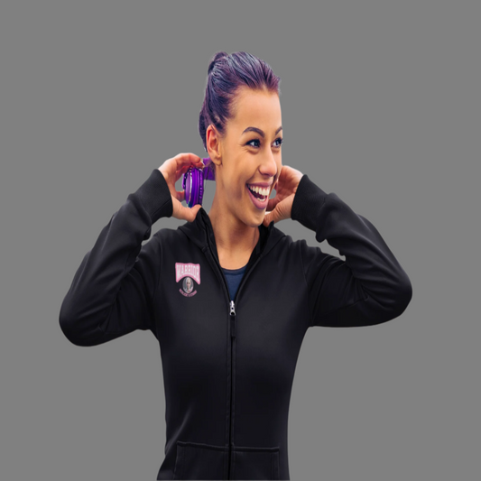 Woman in black jacket holding a purple object on a bridge